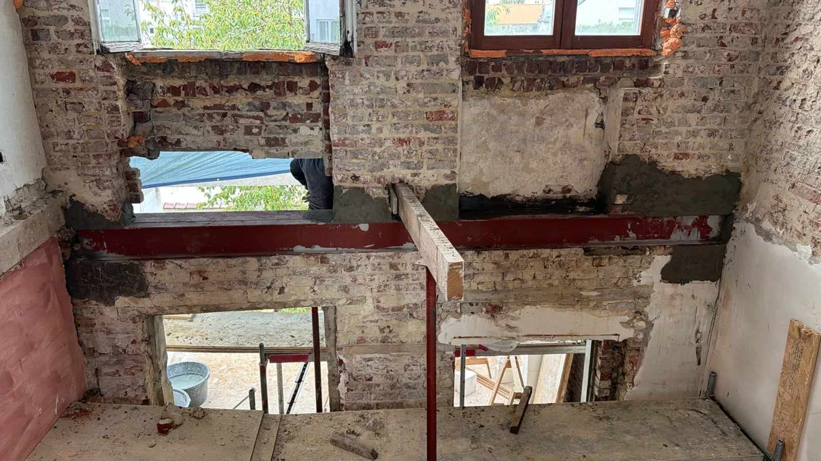 Poutre métallique au-dessus des ouvertures, dans une maçonnerie en cours de travaux.